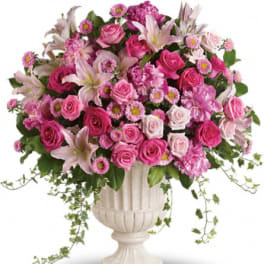 Pink rose and lily arrangement in a white urn vase