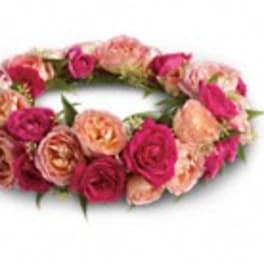 Pink and peach rose floral crown on a white background