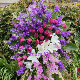 Large standing floral spray with pink roses, white lilies, and purple flowers