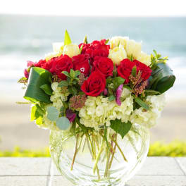 Red and white rose bouquet in a clear glass vase