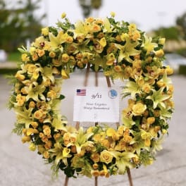 Yellow floral wreath on an easel with a 9/11 remembrance sign