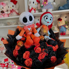 Bouquet of black and orange roses with two plush dolls on top