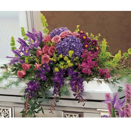 Large casket spray with purple, pink, and yellow flowers