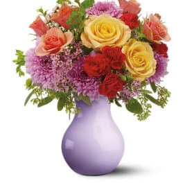 Mixed bouquet of roses and chrysanthemums in a lavender vase