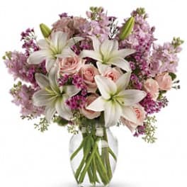 Bouquet of white lilies and pink roses in a clear glass vase