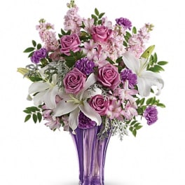 Purple and pink bouquet with white lilies in a tall purple vase