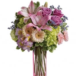 Pink lilies and roses in a clear square vase