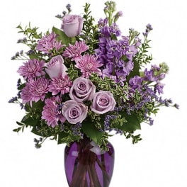 Lavender roses and purple flowers in a purple glass vase