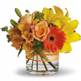 Orange roses and yellow lilies in a clear glass vase