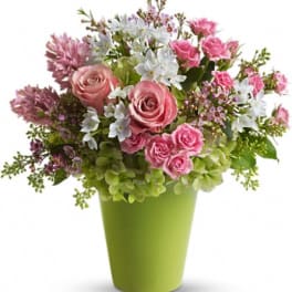 Pink roses and white flowers in a green vase