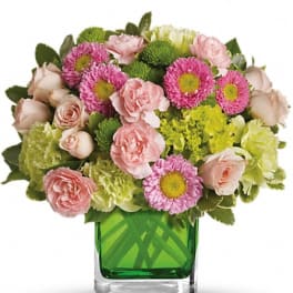 Pink roses and daisies in a green glass vase