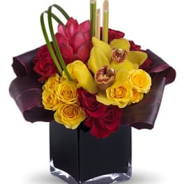 Bouquet of red and yellow flowers in a black square vase