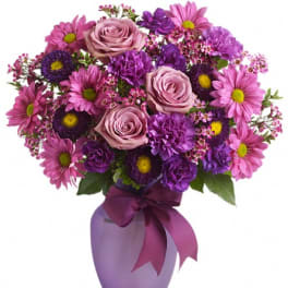 Pink and purple bouquet in a lavender vase with a ribbon