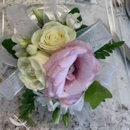 Small bouquet of white and pink flowers wrapped in clear ribbon