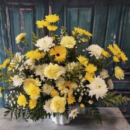 Yellow and white mixed flower arrangement in a white vase
