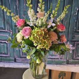 Tall mixed flower arrangement in a clear glass vase