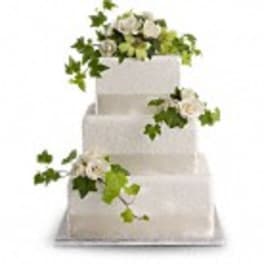 Three-tier white cake with white flowers and green ivy accents