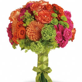 Bouquet of orange, pink, and green flowers tied with a green ribbon
