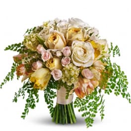 Bouquet of cream and pale pink roses with trailing greenery