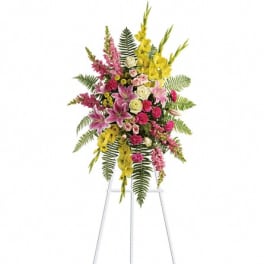 Standing floral spray with pink, yellow, and white flowers on an easel