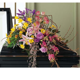 Colorful floral spray arranged on a black casket