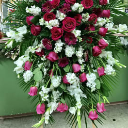 Large standing spray of pink roses, gerbera daisies, and white flowers