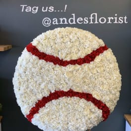 Large round floral display of white and red carnations on an easel