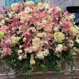 Large pink and white floral casket spray with lilies and roses