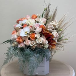 Mixed bouquet of roses, orchids, and calla lilies in a white box