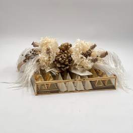 Cream floral arrangement on a gold chocolate box with feather accents