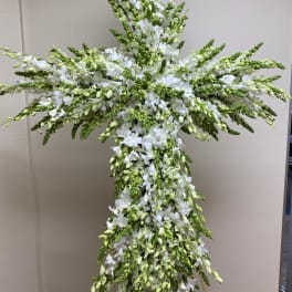 Tall white floral cross arrangement on a stand