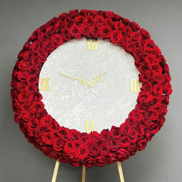 Red rose wreath arranged as a clock face on an easel