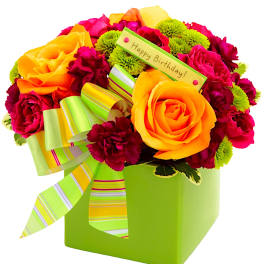Bright bouquet of yellow and pink roses in a green box with a birthday tag