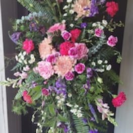 Tall standing floral spray with pink, purple, and white blooms