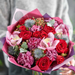 Bouquet of red roses and pink orchids wrapped in pink paper