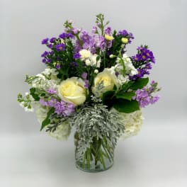 Bouquet of purple and white flowers in a clear glass vase