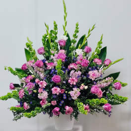 Large bouquet of pink roses and mixed flowers in a white vase