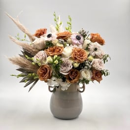 Bouquet of peach and white roses in a gray vase