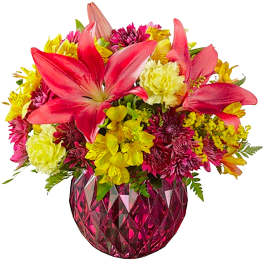 Bright mixed bouquet in a pink faceted vase with lilies and chrysanthemums