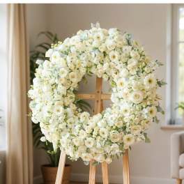 Large white floral wreath on a wooden easel