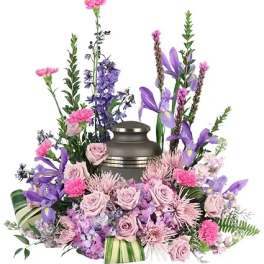 Lavender and pink floral arrangement around a metal urn