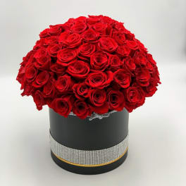 Round bouquet of red roses in a black hat box