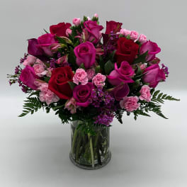 Bouquet of pink and red roses with carnations in a glass vase
