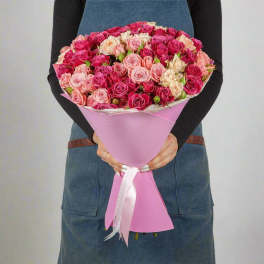 Large bouquet of pink and cream roses wrapped in pink paper