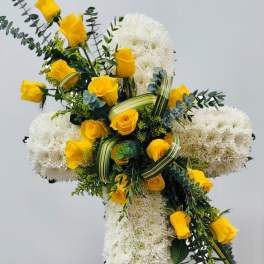 Cross-shaped floral tribute with yellow roses and white chrysanthemums