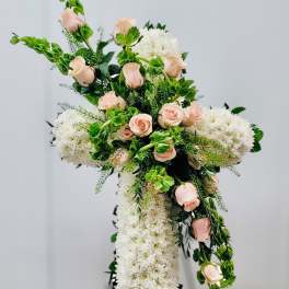 Cross-shaped floral arrangement with pale pink roses and white blooms