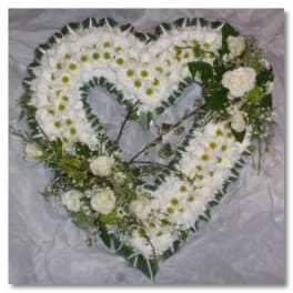Heart-shaped white floral arrangement with green accents