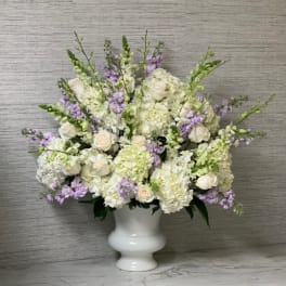 White and lavender floral arrangement in a white vase