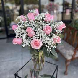 Pink roses and baby's breath in a clear glass vase