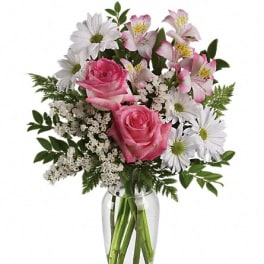 Pink roses and white daisies in a clear glass vase